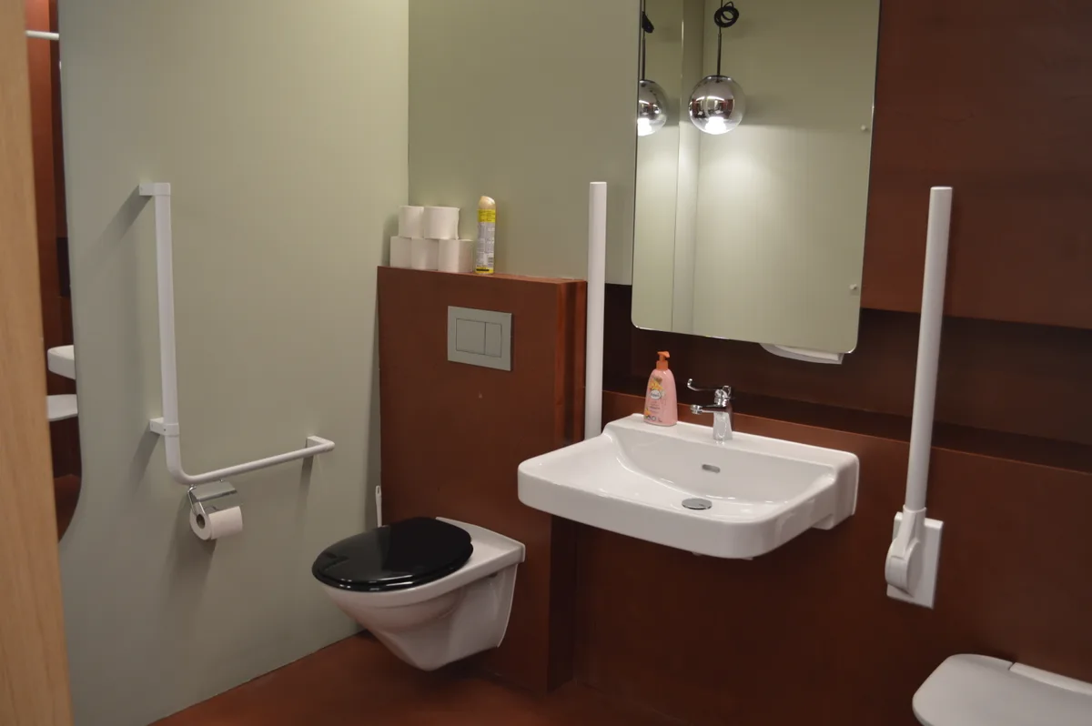 Eine rote Toilette für Rohlstuhlfahrer.